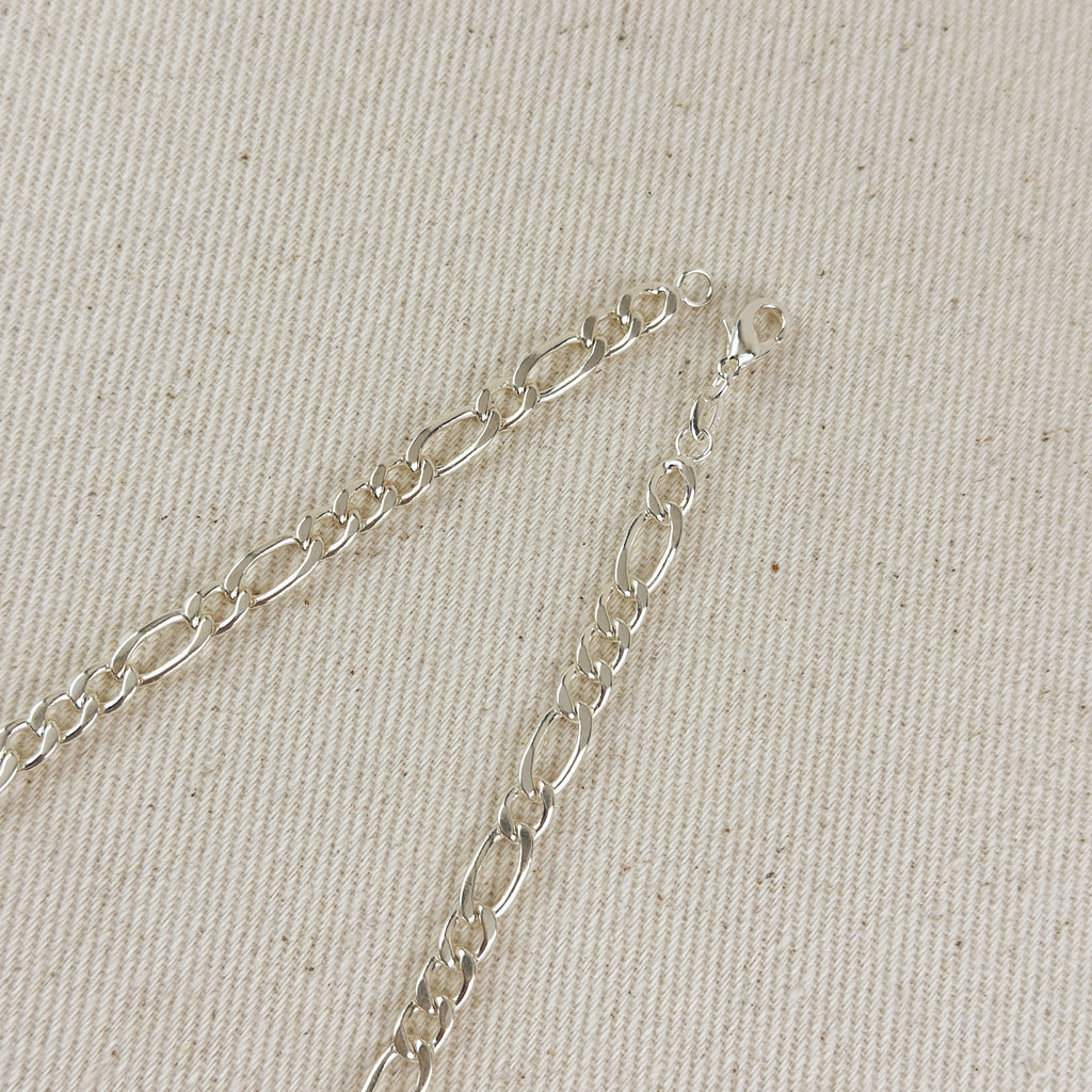 Silver chain bracelet on a beige fabric background