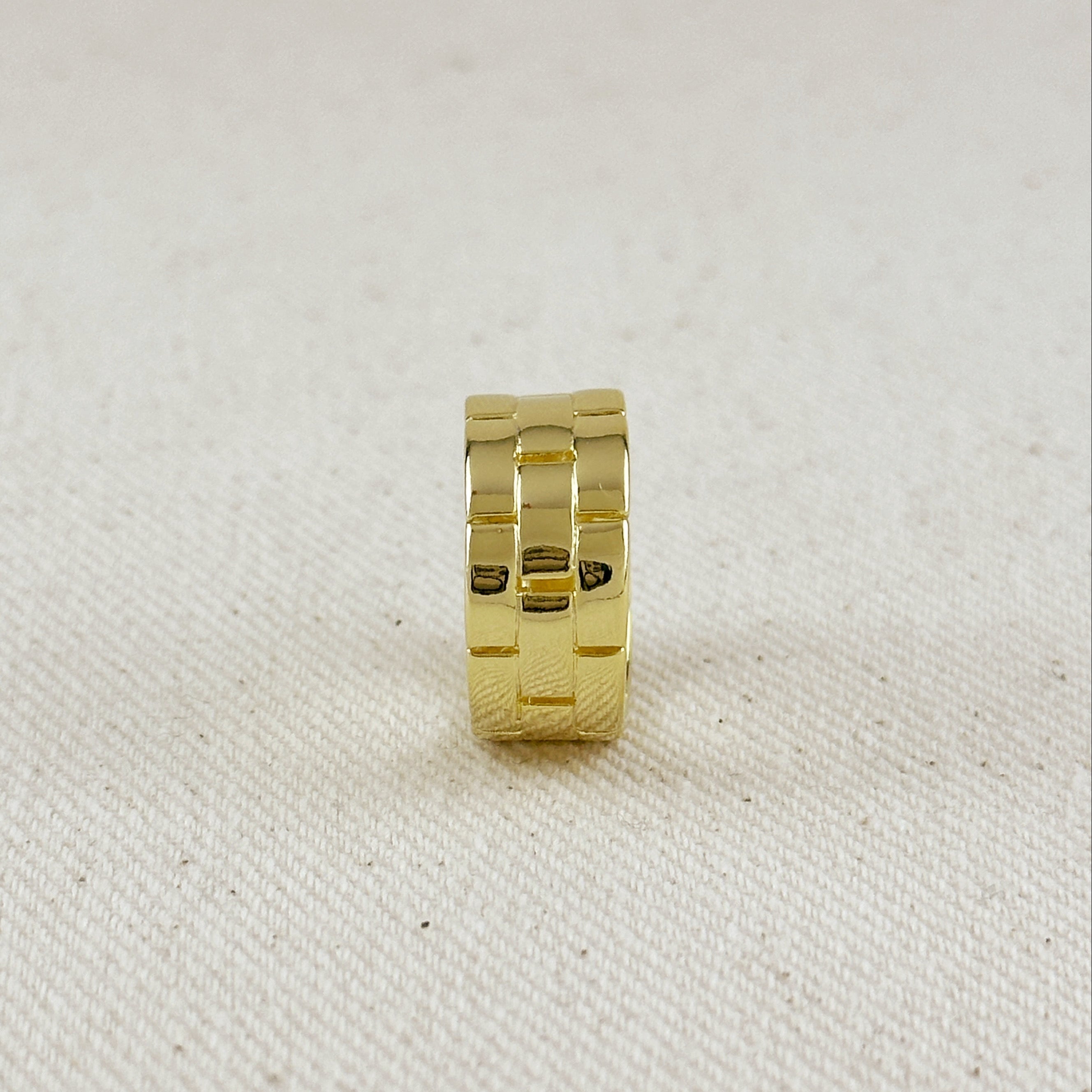 Gold ring on a textured beige background