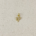 Gold cactus-shaped pendant on a beige fabric background