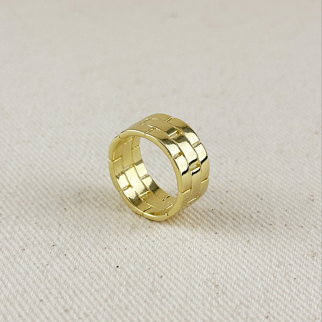 Gold ring with a textured pattern on a beige fabric background