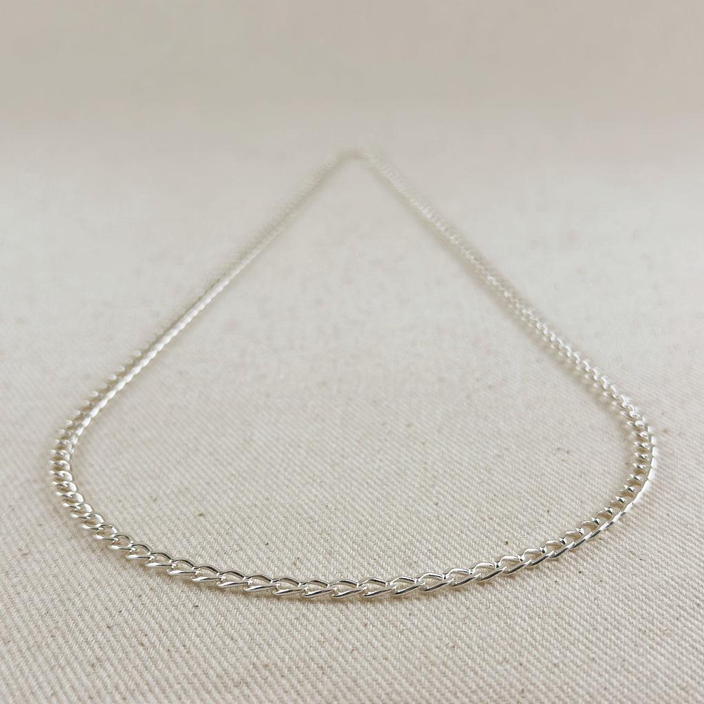 Silver chain necklace on a light beige fabric background