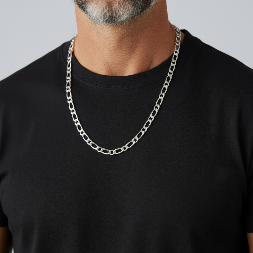 Man wearing a black t-shirt and silver chain necklace against a gray background