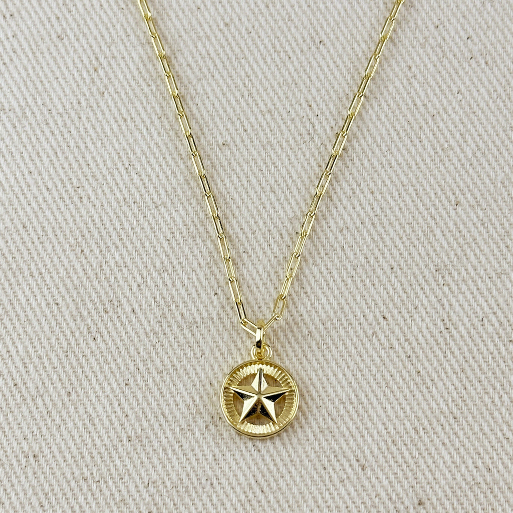 Gold necklace with a star pendant on a beige fabric background