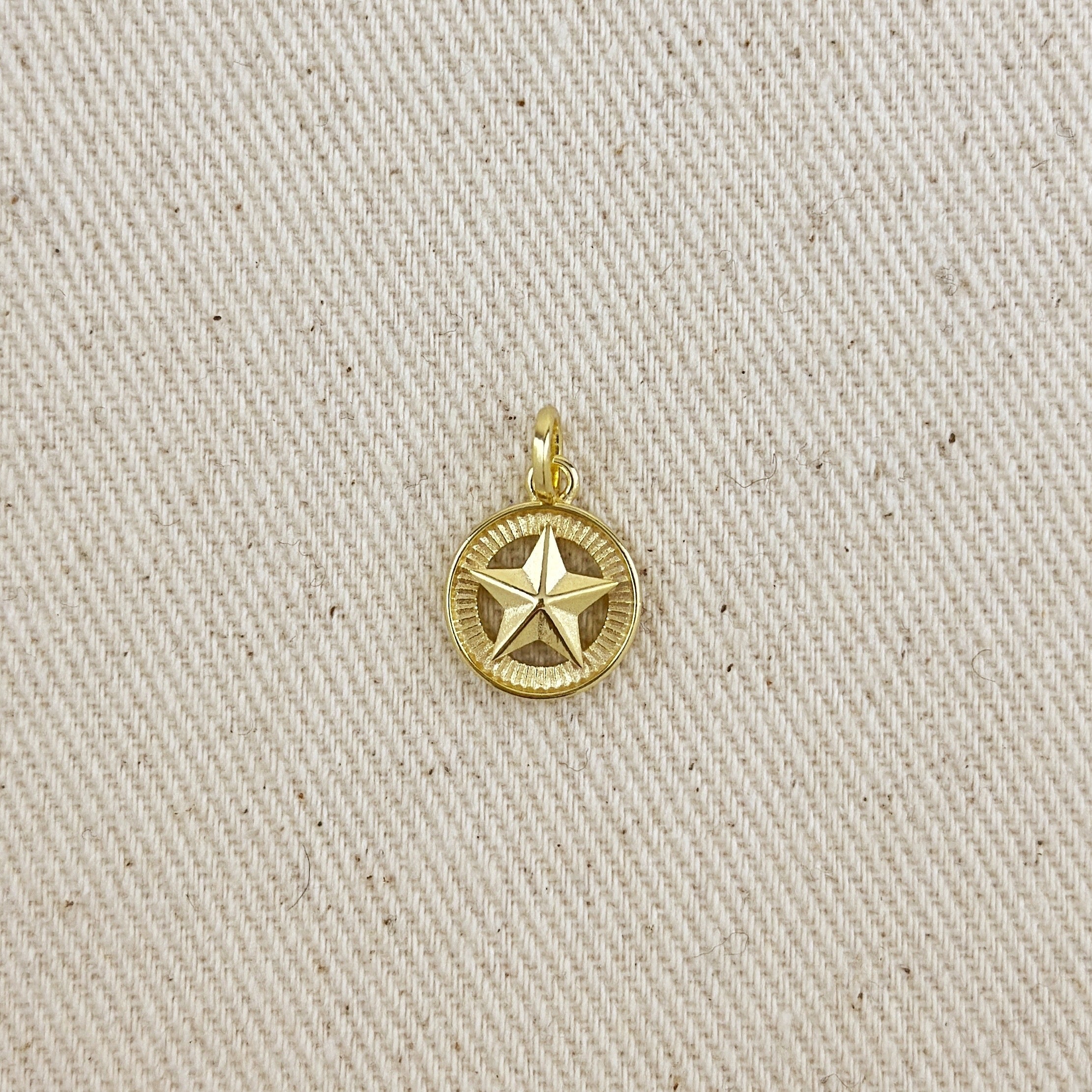 Gold star pendant on a beige fabric background