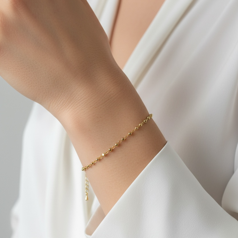 Beaded Gold bracelet on a person's wrist with a white background
