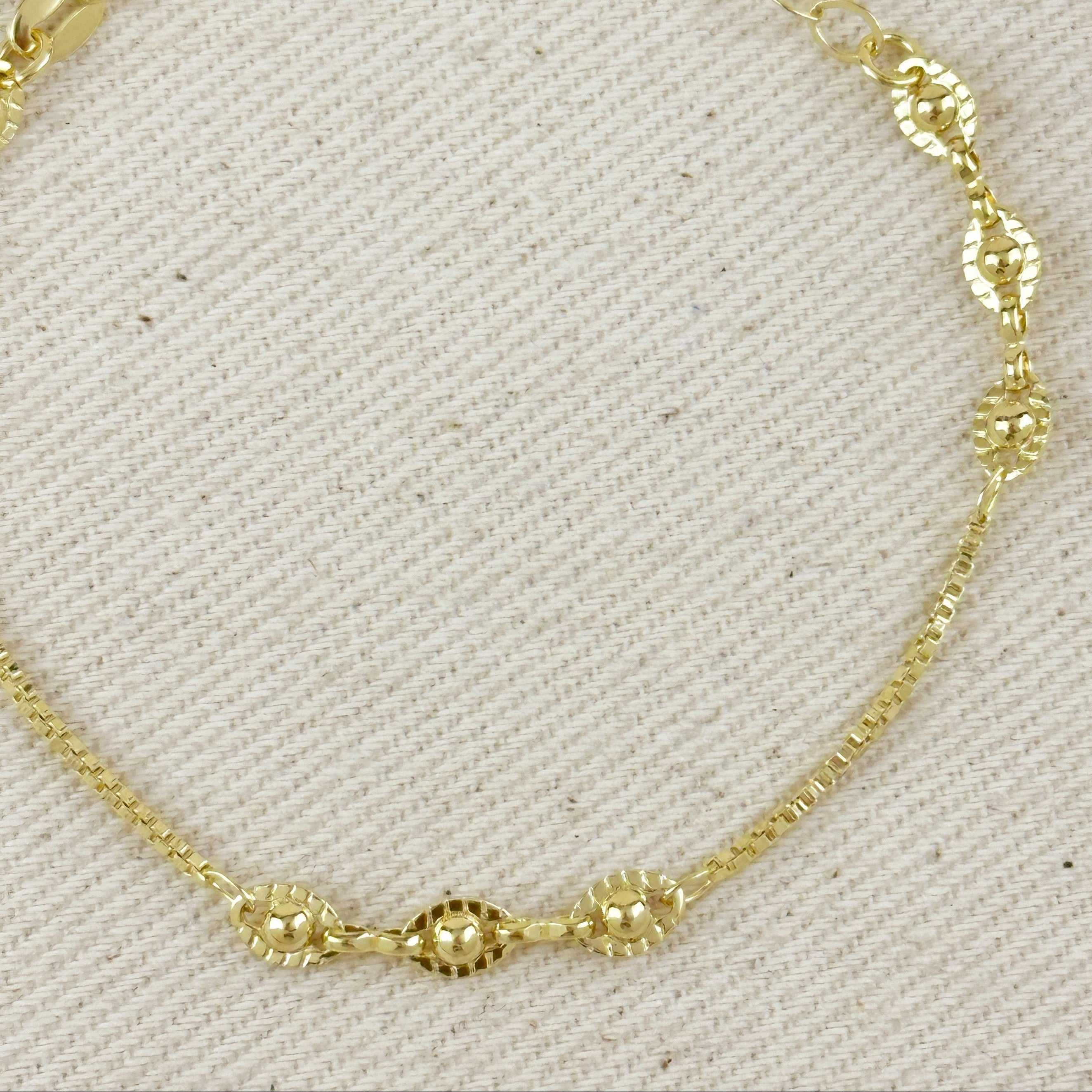 Gold bracelet on a textured beige background